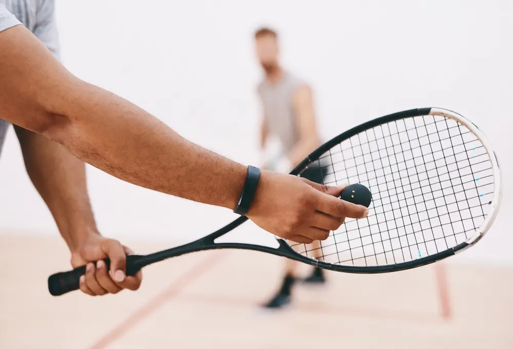 Two squash players holding rackets on court at Scamps Club Surrey